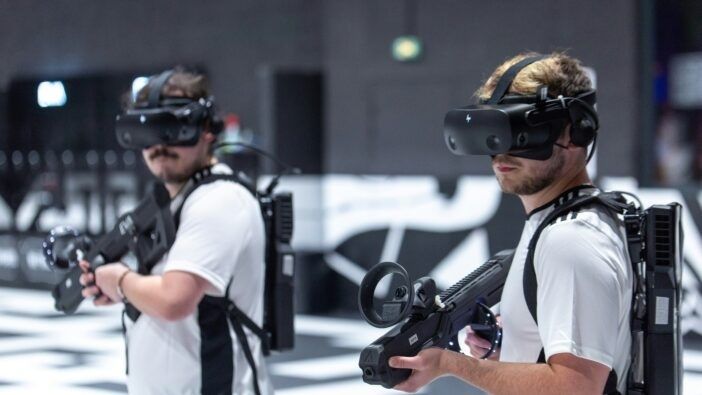 Två personer använder VR-headset och handhållna kontroller tillsammans