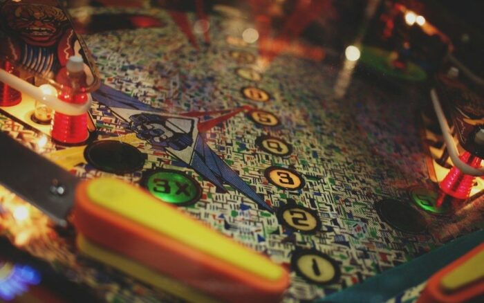 Närbild av ett färgstarkt flipperspel med kulbana och lysande mål